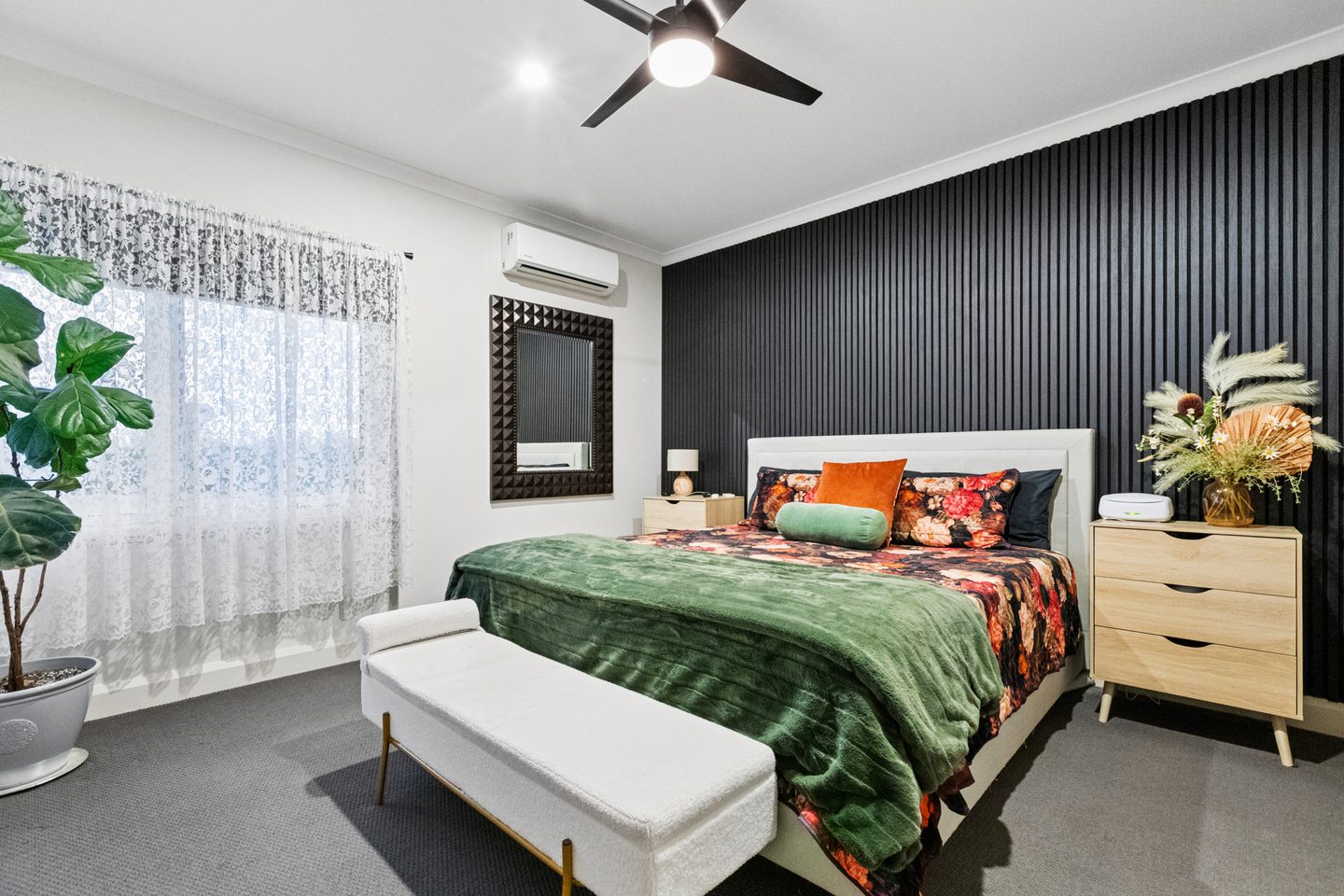 Main bedroom with a dark feature wall and broad windows