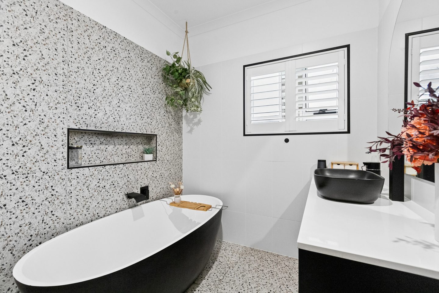 Renovated bathroom with a freestanding bath and dark vanity