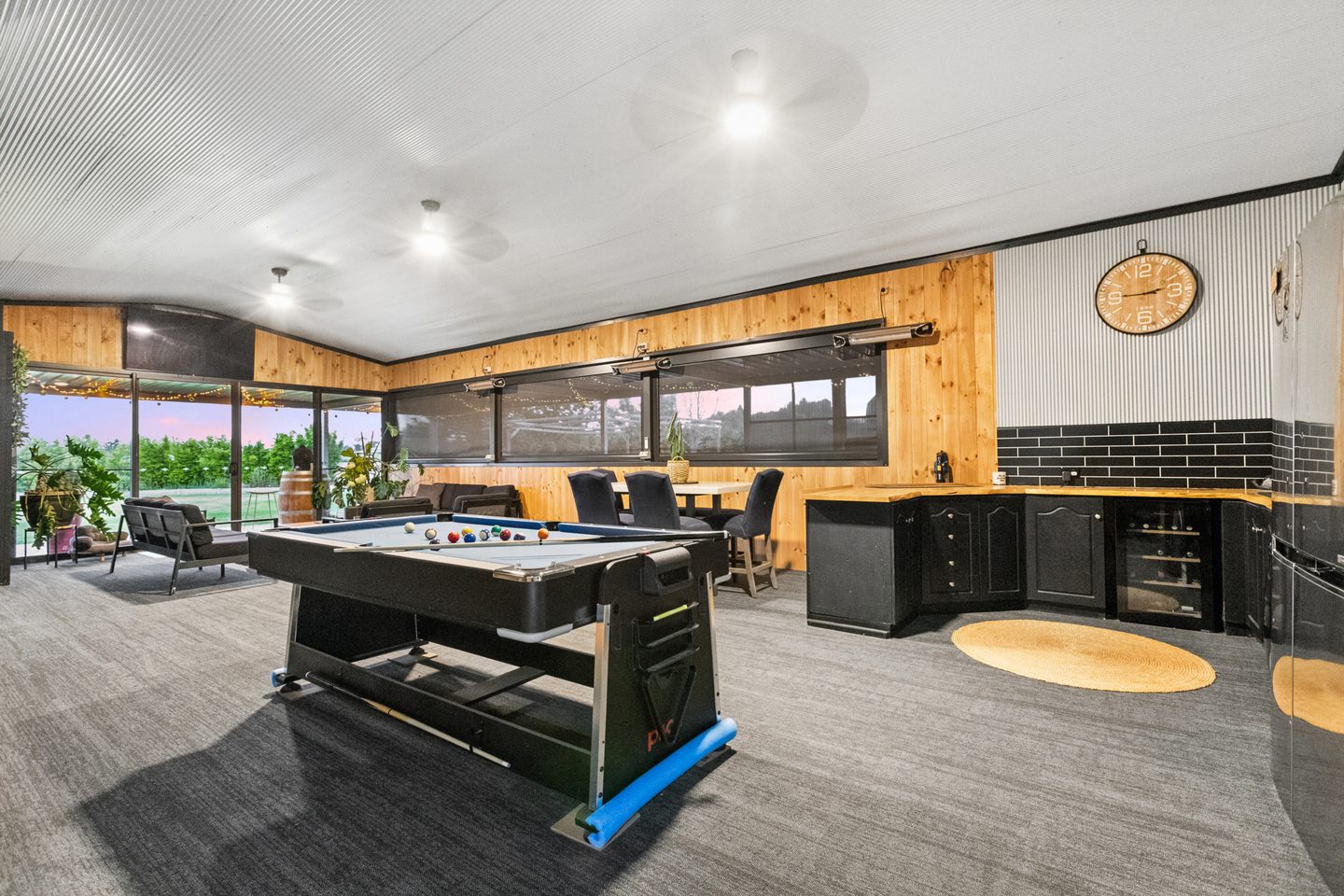 The large rumpus room with built-in bar opening towards the patio